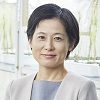 Portrait photo of Professor Keiko Sugimoto smiling with growth chamber plants in background