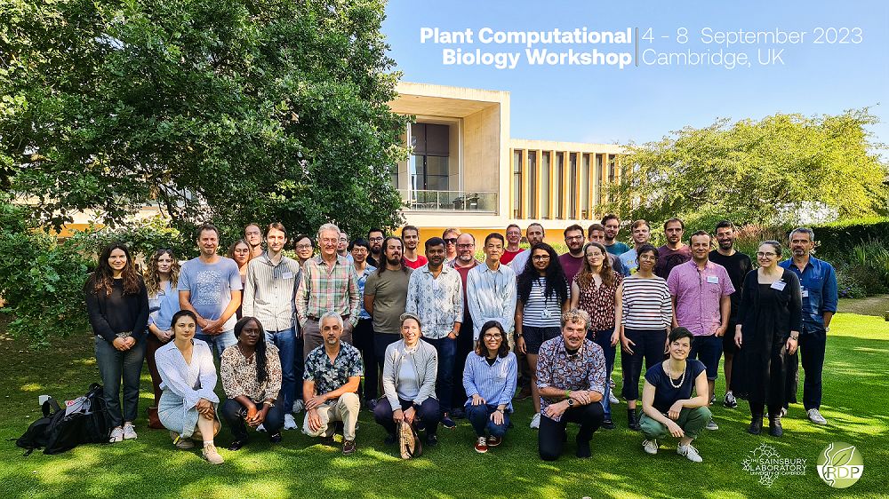 A group photo of the  Plant Computational Biology Workshop 2023 attendees pictured in the Cambridge University Botanic Garden with the Sainsbury Laboratory building in the background.