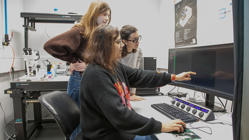 Researchers discussing image on screen in Sainsbury Laboratory microsocpy facility