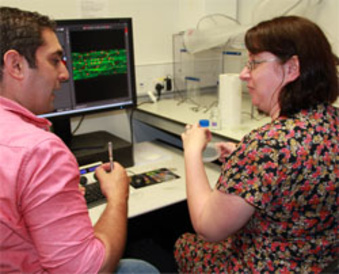 SLCU postdoc Firas Bou Daher showing Biology Teacher Catherine Russell the lab's microscopy facilities.