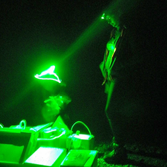 Dora Cano-Ramirez working under green light at night in field experiments in Japan. Dora wears a green headlamp to illuminate the scientific equipment boxes on the ground.